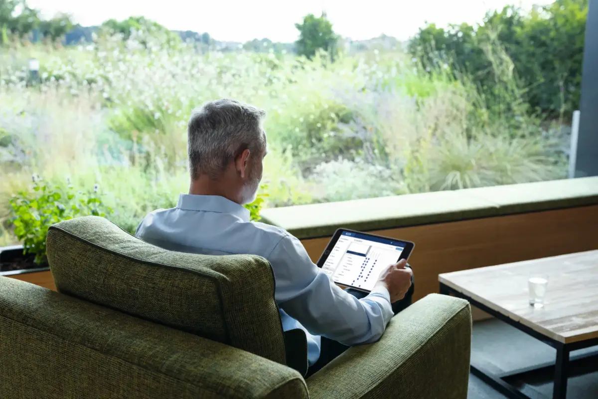 Mann bedient ein Tablet im Sitzbereich eines Bürogebäudes