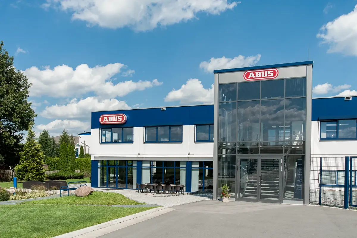 Gebäude von ABUS Pfaffenhain in Jahnsdorf mit gläsernem Eingangsbereich und ABUS-Logo
