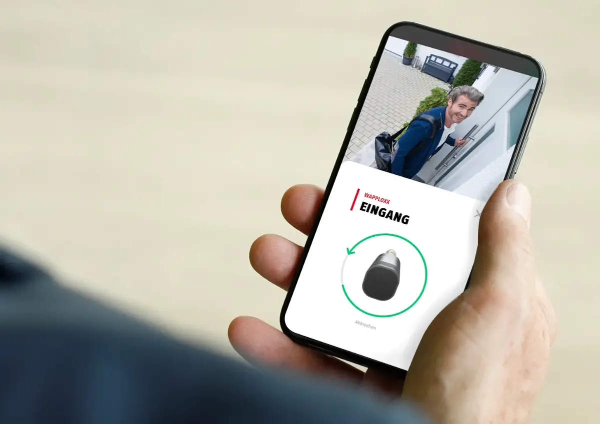 Smartphone mit wAppLoxx-App, Kamerabild und Schaltfläche zur Türfreigabe